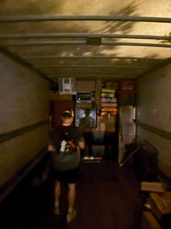 Moving truck interior with organized boxes, appliances, and household items secured for transport