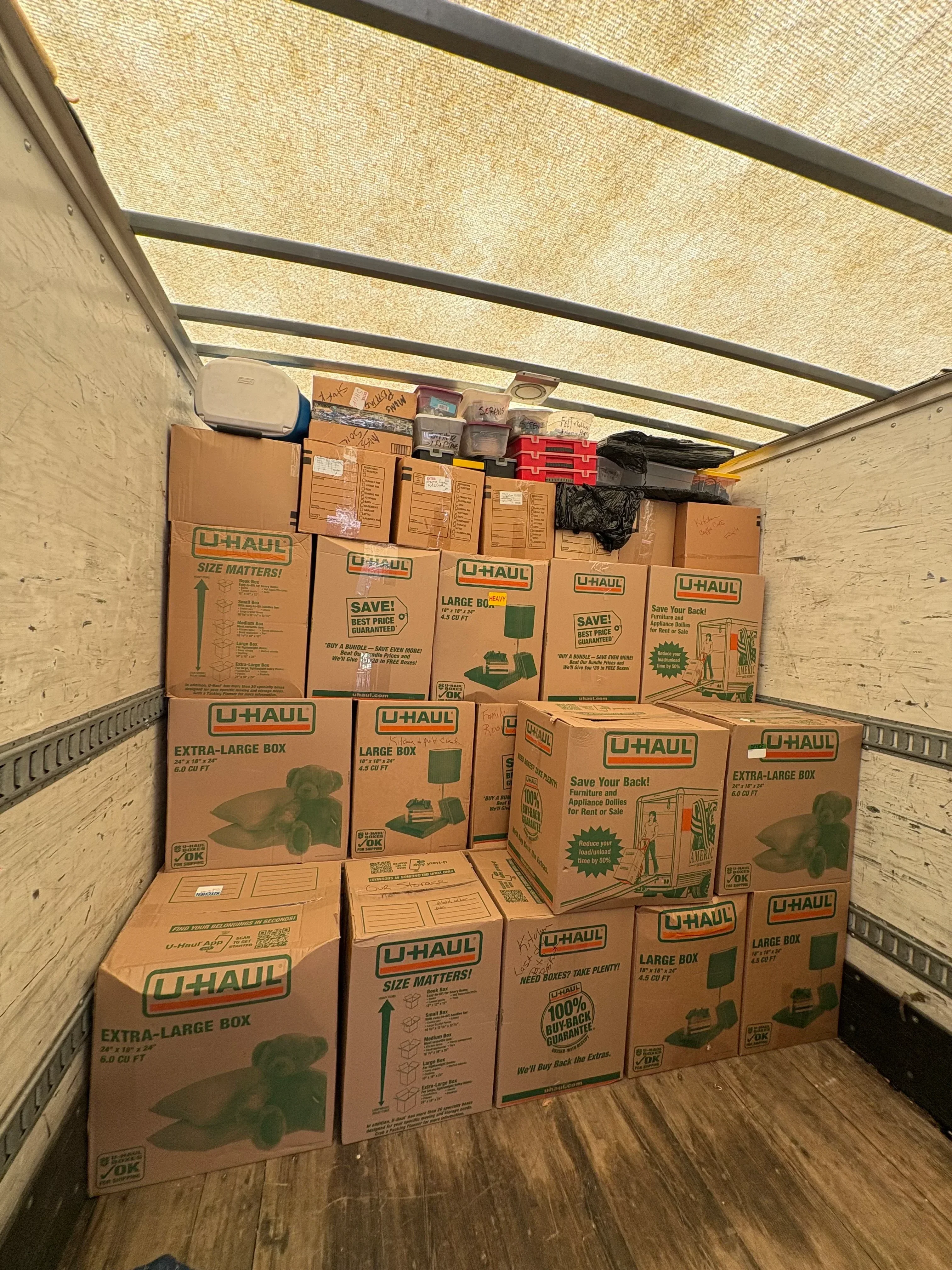 Cardboard moving boxes and supplies loaded in moving truck bed