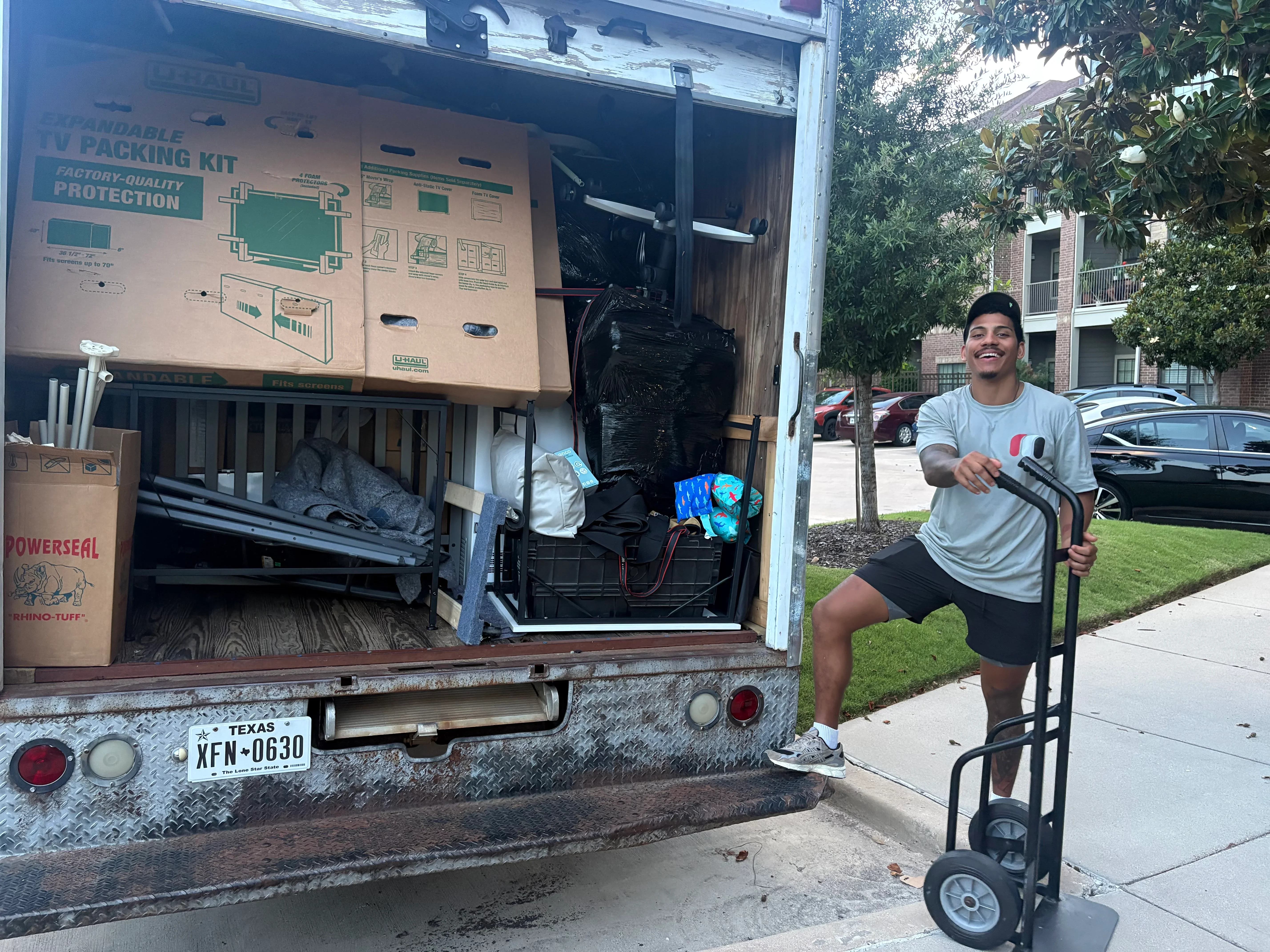 Loaded moving truck with organized packing materials, furniture, and protective coverings