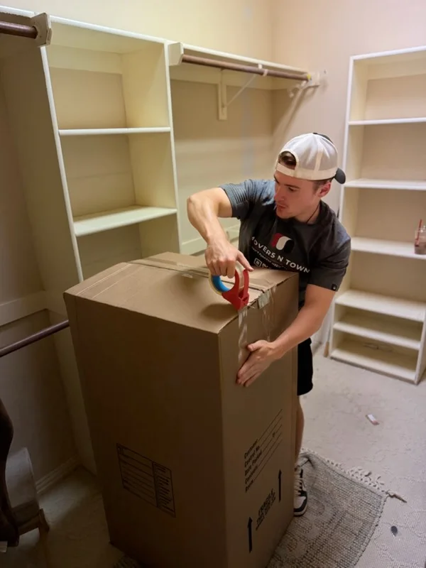 Worker installing white shelving units with metal rods in closet space