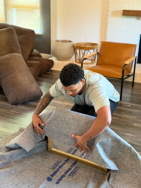 Moving professional wrapping upholstered furniture with protective blankets for transport